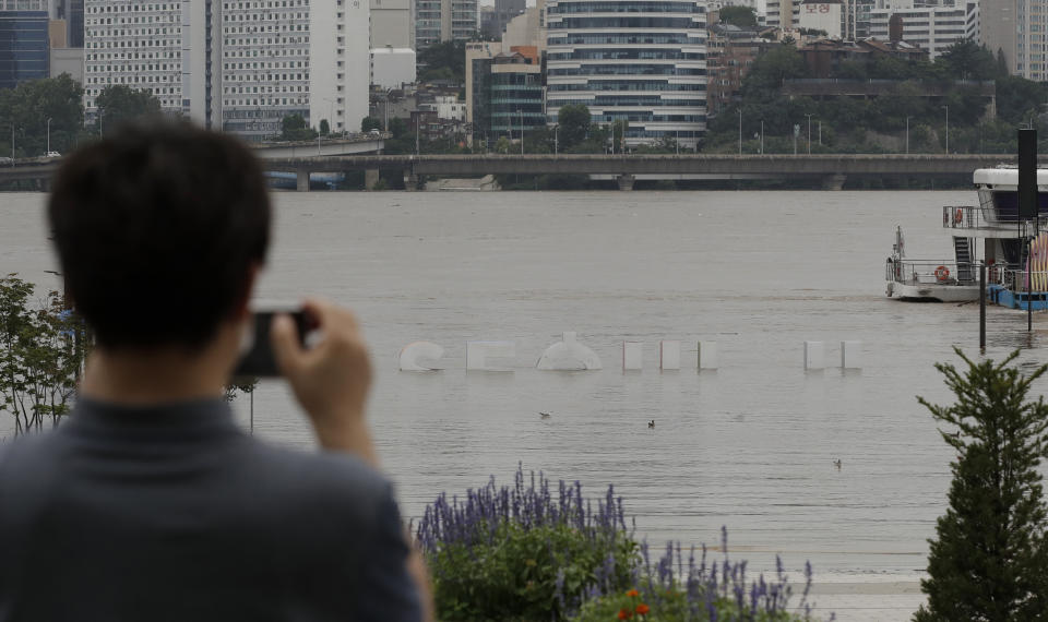 The display of South Korea's capital Seoul logo is partially submerged due to heavy rain at a park near the Han River in Seoul, South Korea, Thursday, Aug. 6, 2020. Torrential rains continuously pounded South Korea on Thursday, prompting authorities to close parts of highways and issue a rare flood alert near a key river bridge in Seoul. (AP Photo/Lee Jin-man)