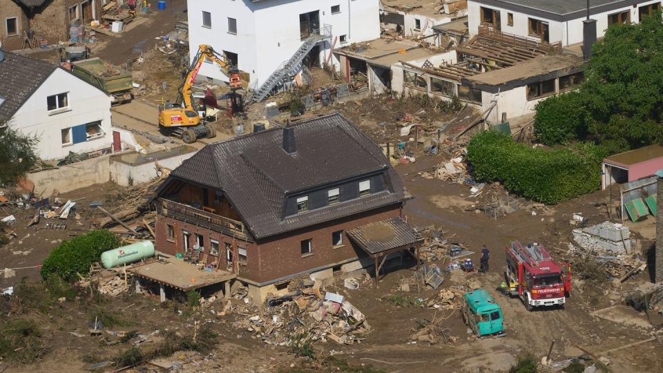 Rettungskräfte sind nach dem Hochwasser im Einsatz. Die Flut hat auch hier zahlreiche Häuser zerstört.