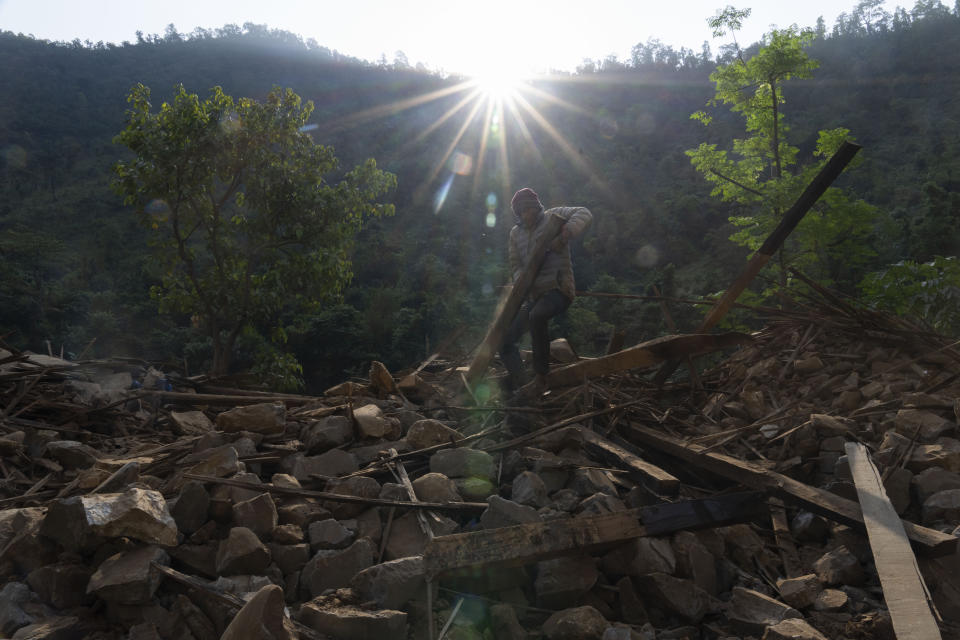 A survivor clears debris as he tries to recover goods from an earthquake damaged house in Rukum District, northwestern Nepal, Monday, Nov. 6, 2023. The Friday night earthquake in the mountains of northwest Nepal killed more than 150 people and left thousands homeless. (AP Photo/Niranjan Shrestha)