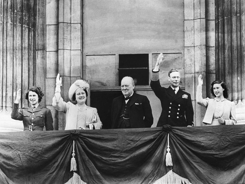 <p>Prime minister Winston Churchill, centre, joins George VI, second right, the then-Queen Elizabeth, second left, and their daughters Elizabeth, left, and Margaret, right, on the balcony of Buckingham Palace to mark the end of the Second World War in Europe – known as Victory in Europe (VE) Day. (Getty)</p> 