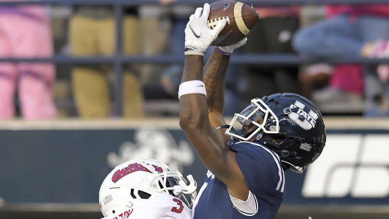 Utah State wide receiver Jalen Royals catches a touchdown pass as Fresno State defensive back Al’zillion Hamilton (3) defends during the first half of an NCAA college football game Friday, Oct. 13, 2023, in Logan, Utah. 