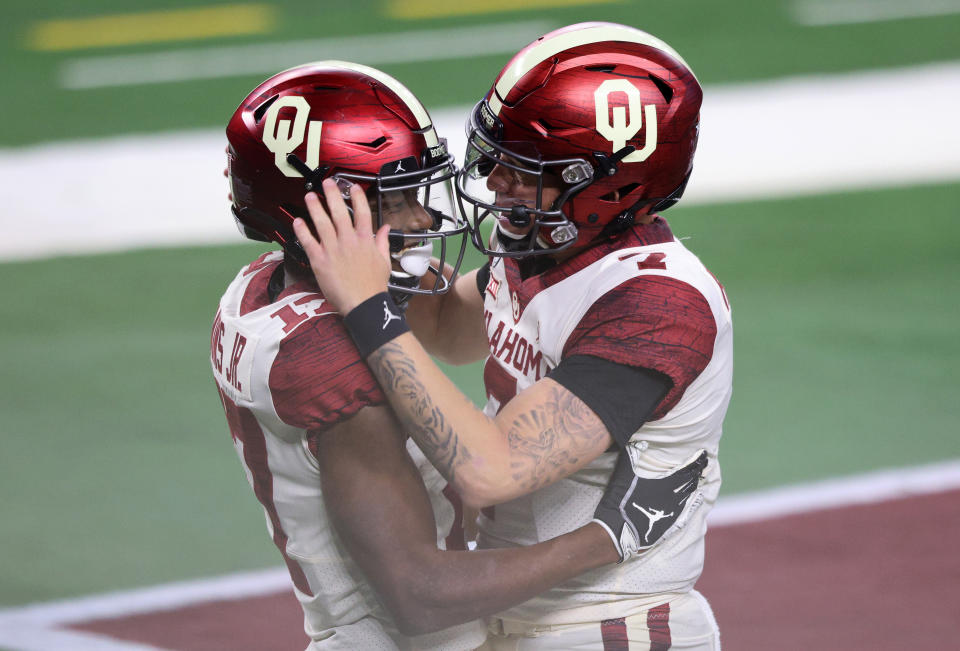 ARLINGTON, TEXAS - DECEMBER 19:  (L-R)  Marvin Mims #17 and Spencer Rattler #7 of the Oklahoma Sooners celebrate a touchdown against the Iowa State Cyclones in the first half during the 2020 Big 12 Championship at AT&T Stadium on December 19, 2020 in Arlington, Texas. (Photo by Ronald Martinez/Getty Images)