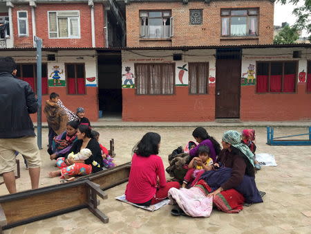 People take refuge at a school after a 7.7 magnitude earthquake struck in Kathmandu