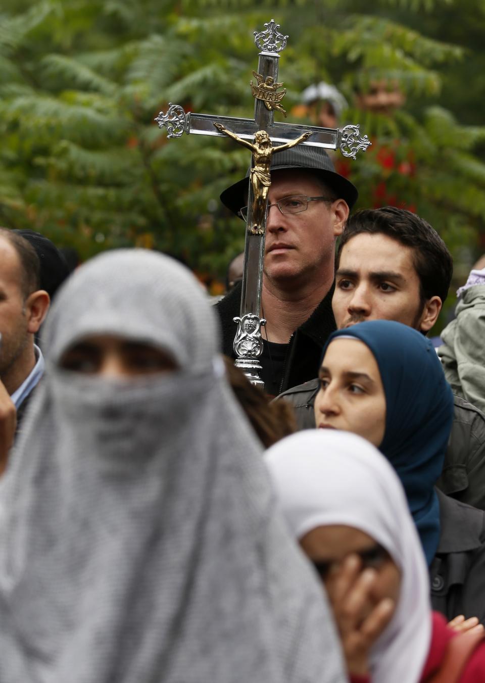 A man carries a cross during a protest against Quebec's proposed Charter of Values in Montreal, September 14, 2013. Thousands took to the streets to denounce the province's proposed bill to ban the wearing of any overt religious garb by government paid employees. REUTERS/ Christinne Muschi (CANADA - Tags: POLITICS CIVIL UNREST)