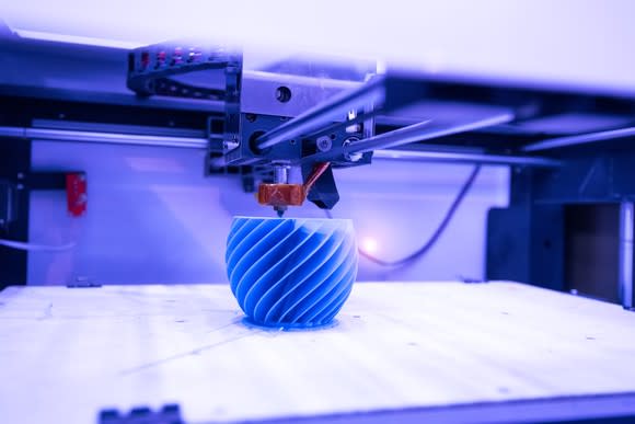 A 3D printer carving out a shape.