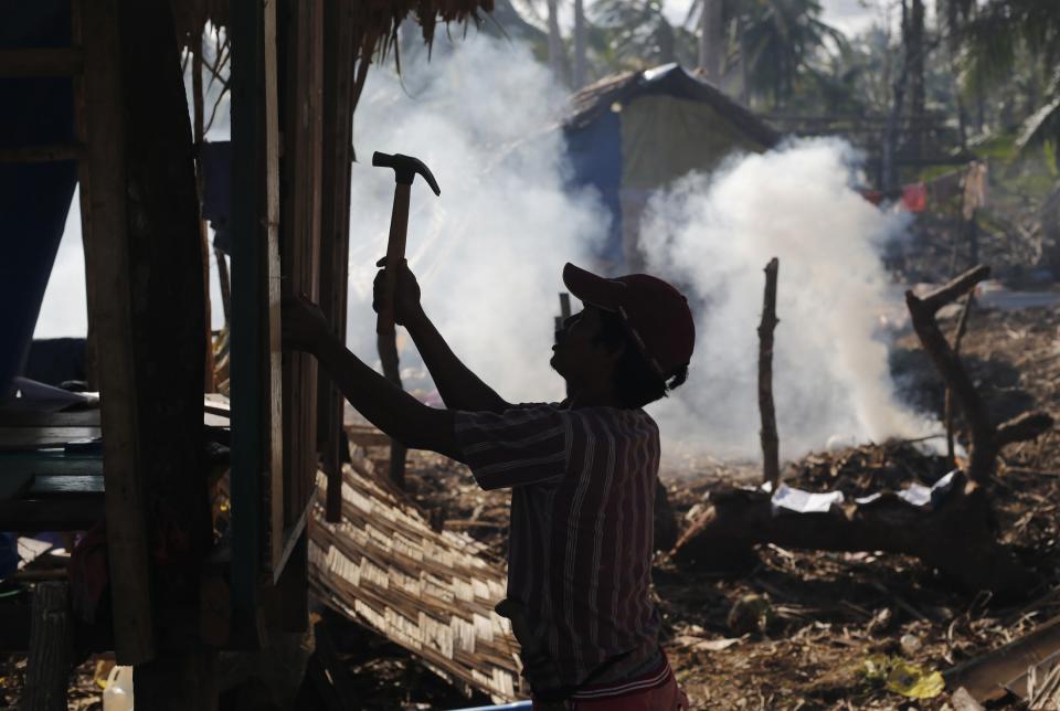 A survivor of Typhoon Haiyan builds a new house from the remnants of his previous one in the eastern Samar costal village of Hernani