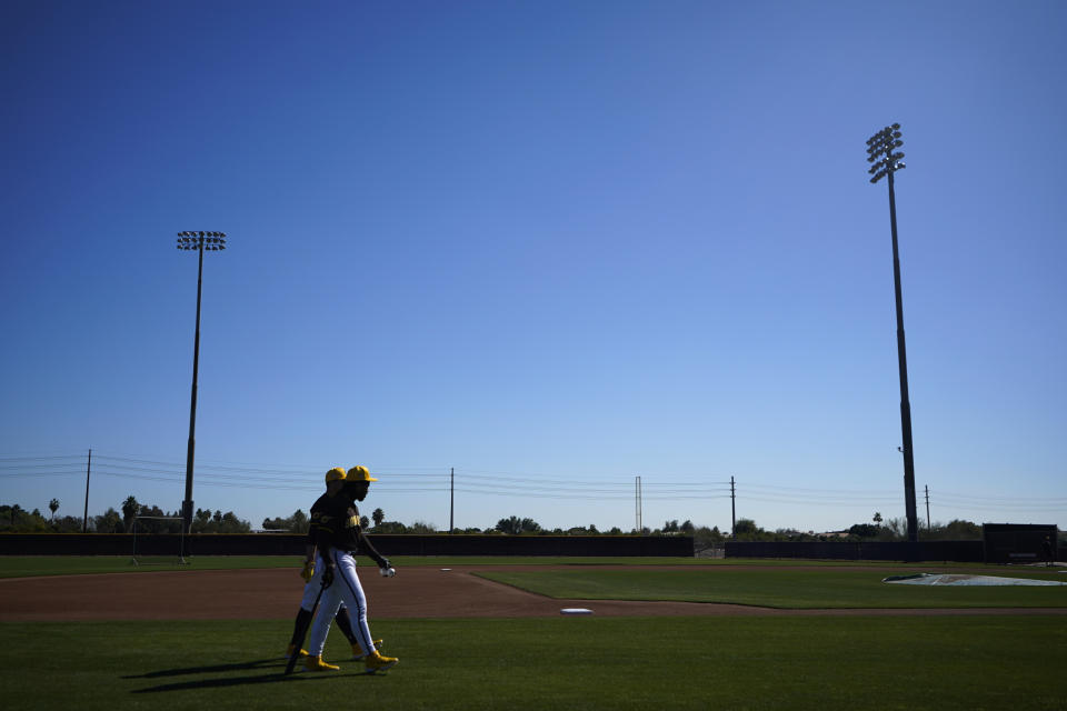 San Diego Padres catcher Luis Campusano, left, and catcher Kyle Higashioka, back left, walk off a practice field during spring training baseball workouts Tuesday, Feb. 13, 2024, in Peoria, Ariz. (AP Photo/Lindsey Wasson)