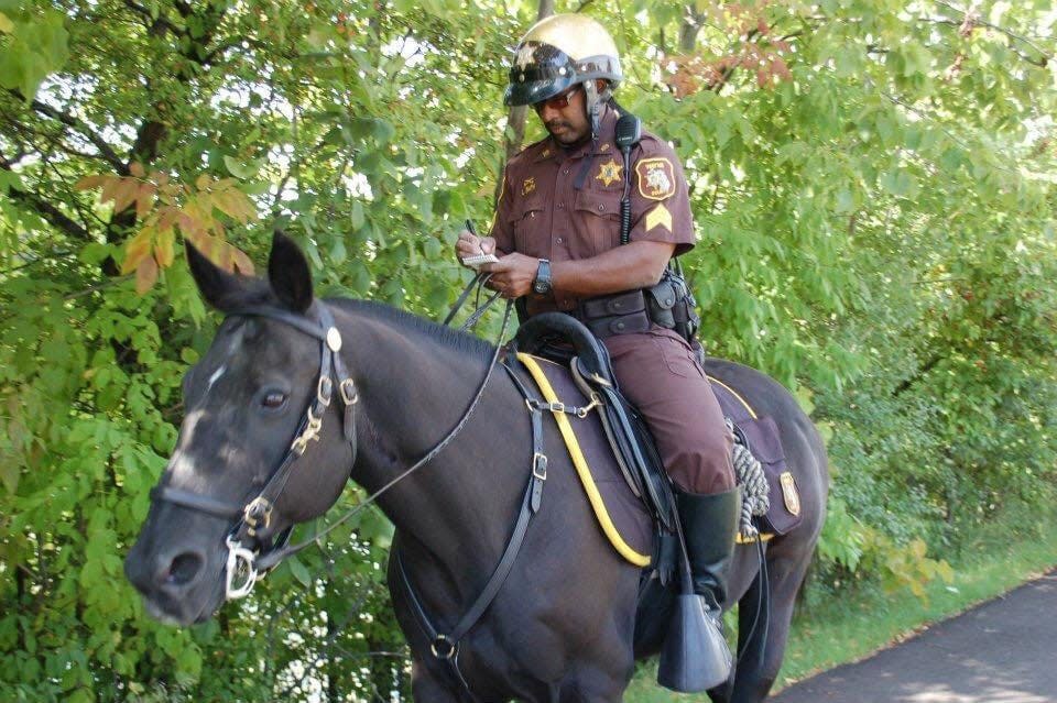 Sgt. Lee Eric Smith riding Wayne County Sheriff's Office Mounted Division horse Doc while on patrol in Hines Park in Livonia in this undated photo. Sgt. Smith died after being struck by a car while jogging in August 2018. Doc died in September 2021. Doc's remains will be interred at the Michigan War Dog Memorial cemetery in Lyon Township.