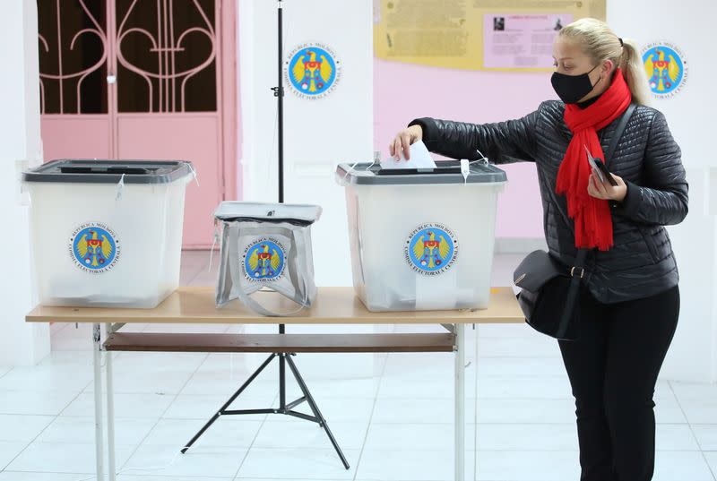 A woman casts her ballot at a polling station during the second round of a presidential election in Chisinau