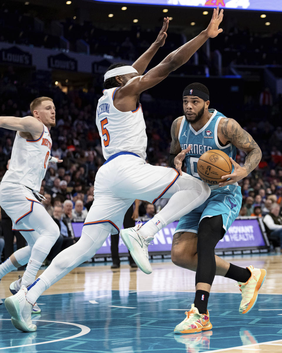 Charlotte Hornets forward Miles Bridges (0) drives to the basket while guarded by New York Knicks forward Precious Achiuwa (5) during the first half of an NBA basketball game Monday, Jan. 29, 2024, in Charlotte, N.C. (AP Photo/Jacob Kupferman)