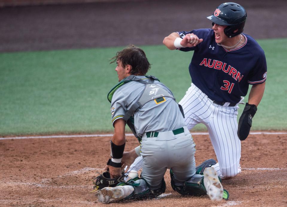 Auburn Tigers outfielder Mike Bello (31) slides safely into home plate beating Southeastern Louisiana Lions catcher Bryce Grizzaffi (1)as Auburn Tigers take on Southeastern Louisiana Lions during the NCAA regional baseball tournament at Plainsman Park in Auburn, Ala., on Friday, June 3, 2022. 