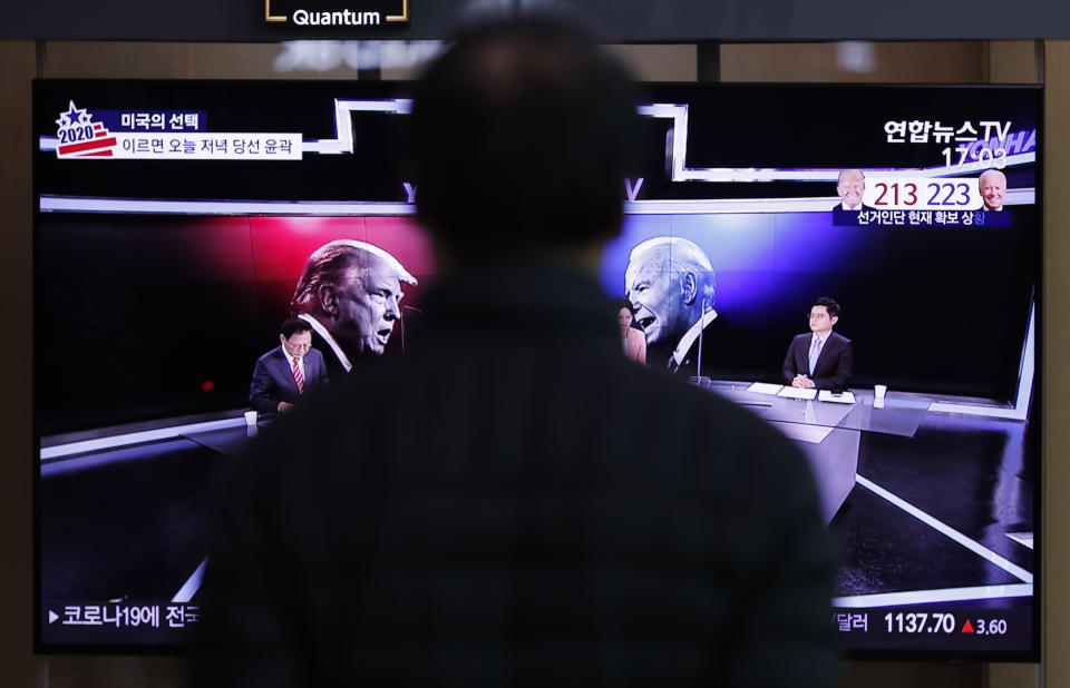 A man watches a TV screen showing the images of U.S. President Donald Trump and Democratic presidential candidate former Vice President Joe Biden during a news program of the U.S. presidential election, at the Seoul Railway Station in Seoul, South Korea, Wednesday, Nov. 4, 2020. (AP Photo/Lee Jin-man)
