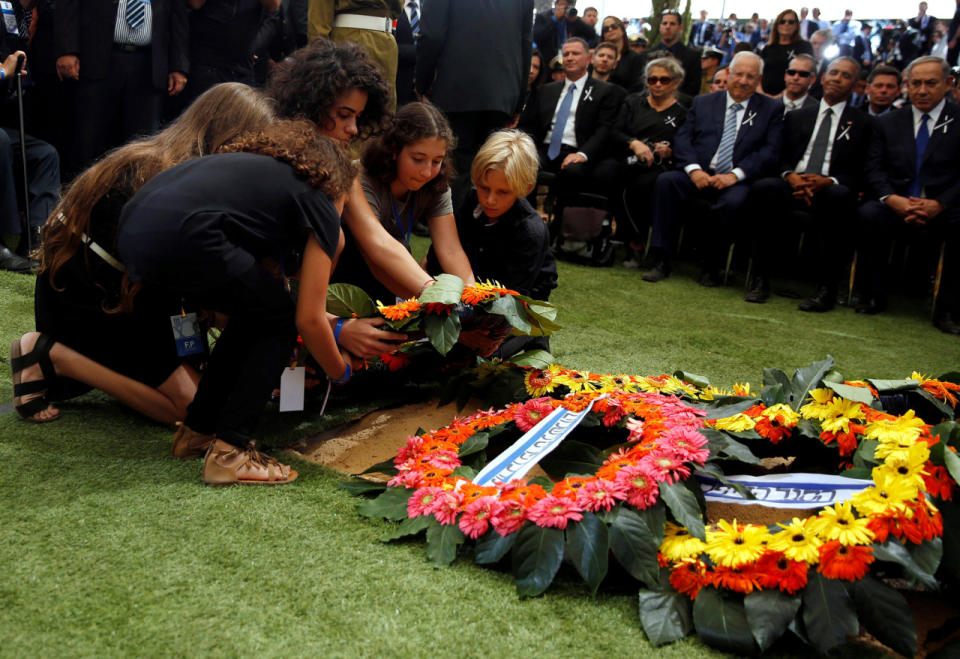 <p>Grandchildren of former Israeli President Shimon Peres lay a wreath on the grave of their grandfather during the burial ceremony at Mount Herzl Cemetery in Jerusalem on Sept. 30, 2016. (REUTERS/Ronen Zvulun)</p>