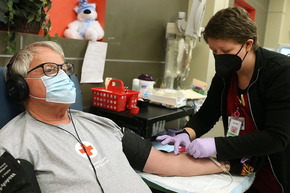 Collection specialist Chelsea Crowley of the American Red Cross inserts the return line into the arm of Donald Conboy, of Weymouth, who was donating platelets at the Weymouth Red Cross Blood Donation Center on Tuesday, Jan. 18, 2022. He has been donating platelets for about 10 years. The Weymouth Donation Center collects blood daily from donors by appointment. Walk-ins are welcome if staff is available.