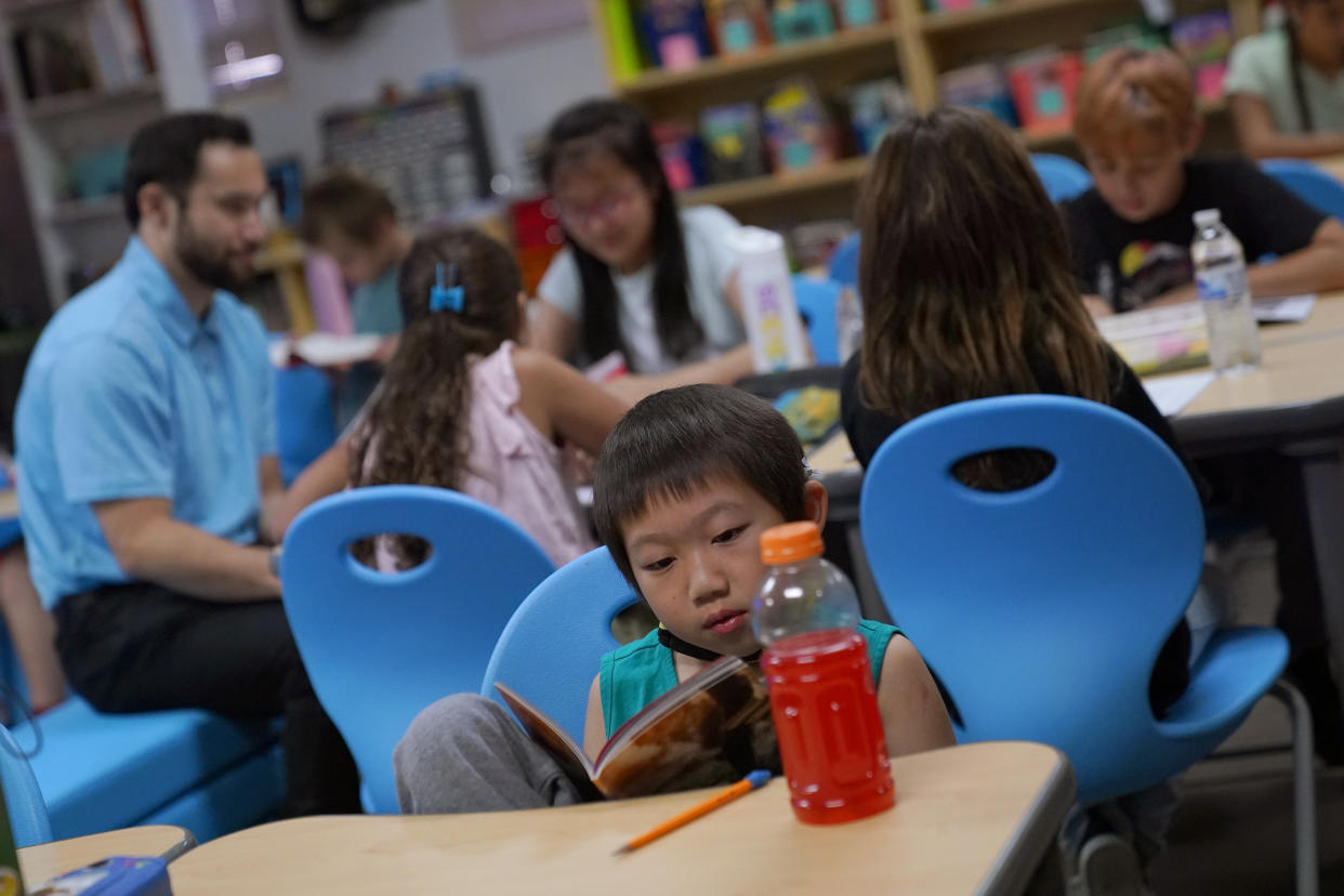 Students at Whittier Elementary School work in groups and independently, Tuesday, Oct. 18, 2022 in Mesa, Ariz. Like many school districts across the country, Mesa has a teacher shortage due in part due to low morale and declining interest in the profession. Five years ago, Mesa allowed Whittier to participate in a program making it easier for the district to fill staffing gaps, grant educators greater agency over their work and make teaching a more attractive career. The model, known as team teaching, allows teachers to combine classes and grades rotating between big group instruction, one-on-one interventions, small study groups or whatever the team agrees is a priority each day. (AP Photo/Matt York)