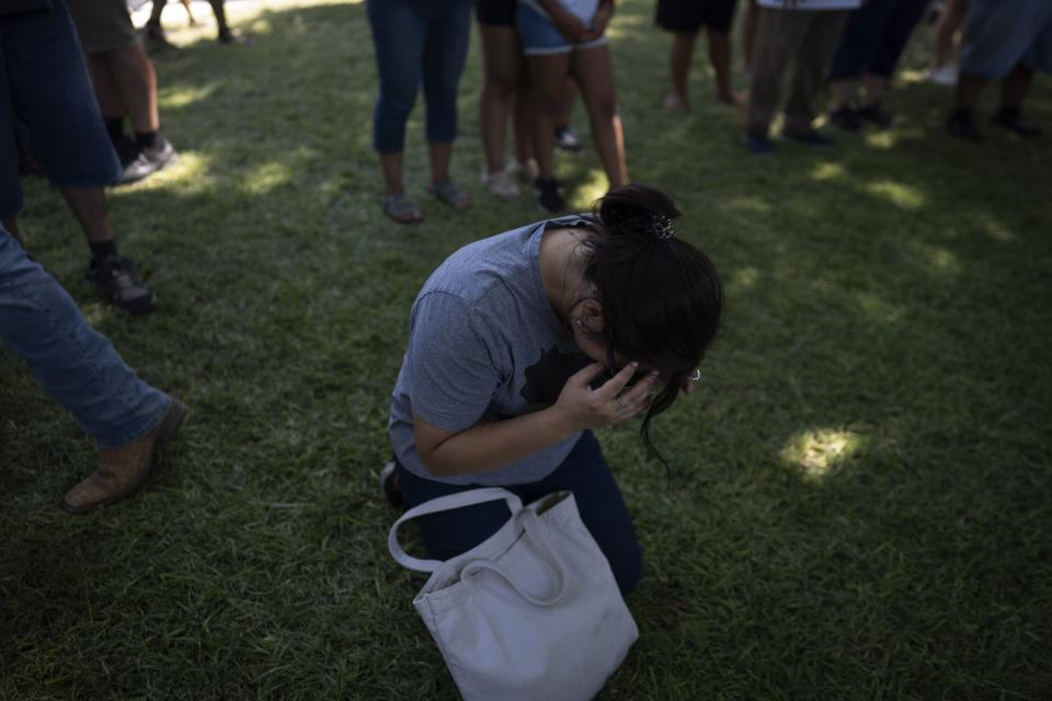 A woman weeps as she prays at the memorial site for victims of the mass shooting at Robb Elementary School in the town square of Uvalde, Texas on Saturday, May 28, 2022. In a town as small as Uvalde, even those who didn't lose their own child lost someone. Some say now that closeness is both their blessing and their curse: they can lean on each other to grieve. But every single one of them is grieving. (AP Photo/Wong Maye-E)