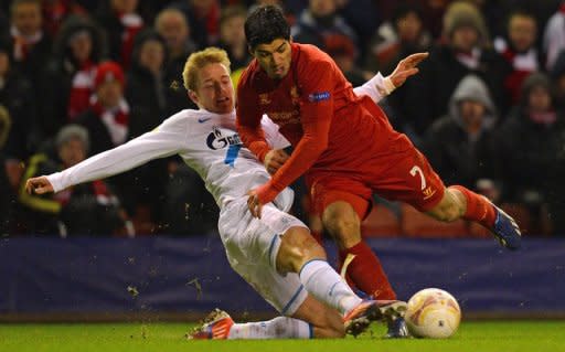El atacante uruguayo del Liverpool Luis Suárez (D), intenta escapar de la marca del defensa del Zenit de San Petersburgo Tomas Hubocan, en partido de dieciseisavos de final de la Europa League jugado el 21 de febrero de 2013 en Liverpool. (AFP | andrew yates)