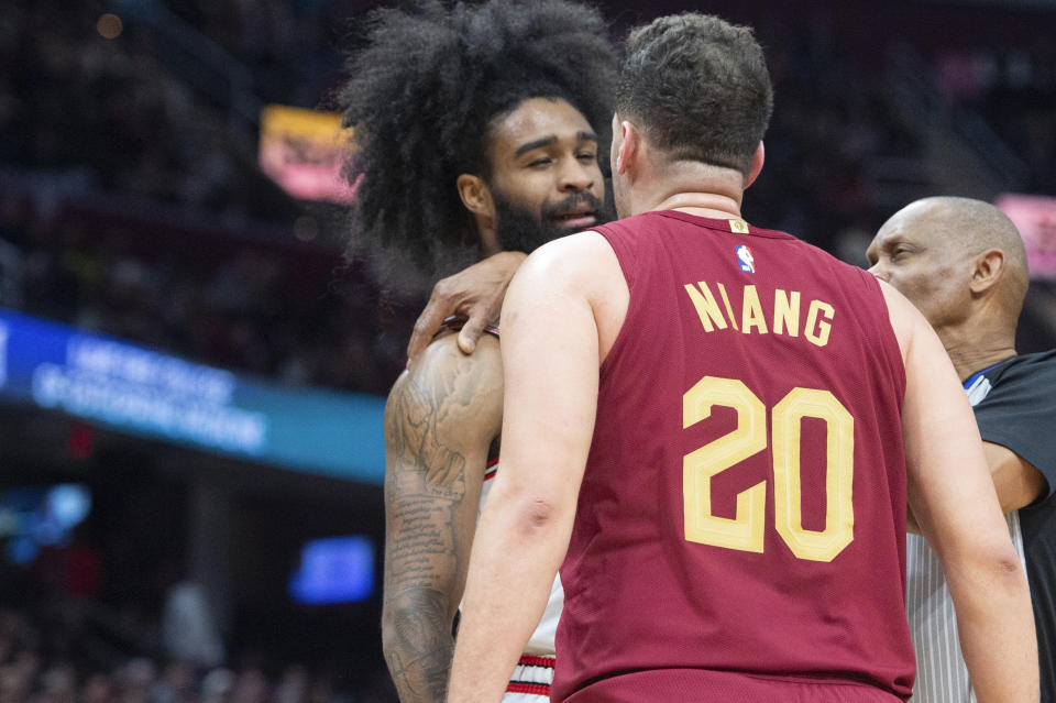 Referee Michael Smith separates Chicago Bulls' Coby White left, and Cleveland Cavaliers' Georges Niang (20) during the second half of an NBA basketball game in Cleveland, Wednesday, Feb. 14, 2024. (AP Photo/Phil Long)