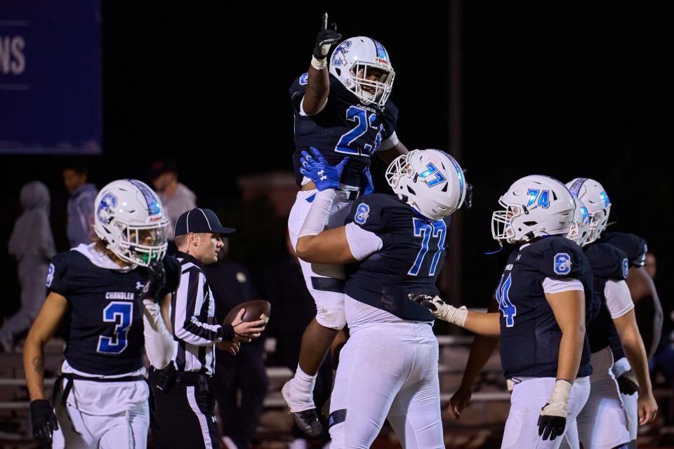 Chandler Wolves running back Charles Ennis Jr (23) is hoisted into the air by offensive tackle Zarius Wells (77) at Chandler High School's Austin Field on Friday, Nov. 25, 2022.