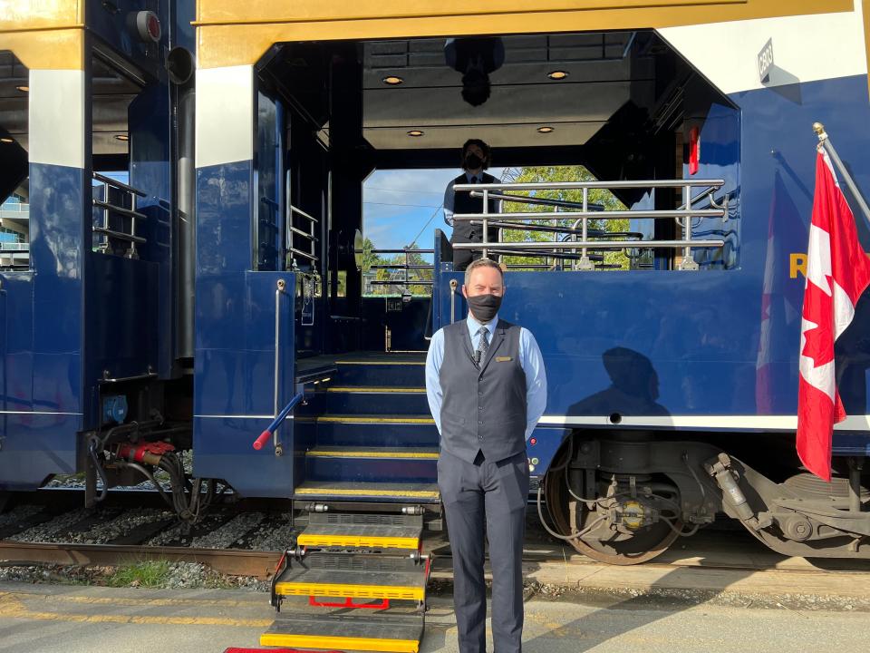 A staff member from the Rocky Mountaineer stands by entrance to train car