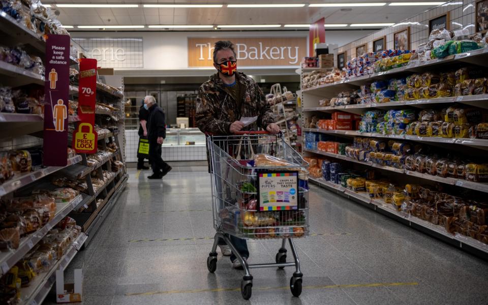 A man wearing a Union Jack flag design face mask shops in a Sainsbury's supermarket - Chris J Ratcliffe/Getty Images