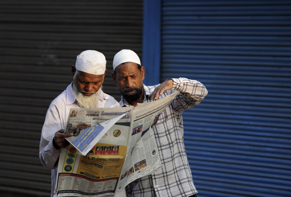 FILE - In this Nov. 10, 2019, file photo, Indian Muslims read a newspaper reporting about a Supreme Court verdict favoring the building of a Hindu temple on a site in a decades-old land title dispute between Muslims and Hindus in Ayodhya, India. As Hindus prepare to celebrate the groundbreaking of a long-awaited temple at a disputed ground in northern India, Muslims say they have no firm plans yet to build a new mosque at an alternative site they were granted to replace the one torn down by Hindu hard-liners decades ago. (AP Photo/Rajesh Kumar Singh, File)