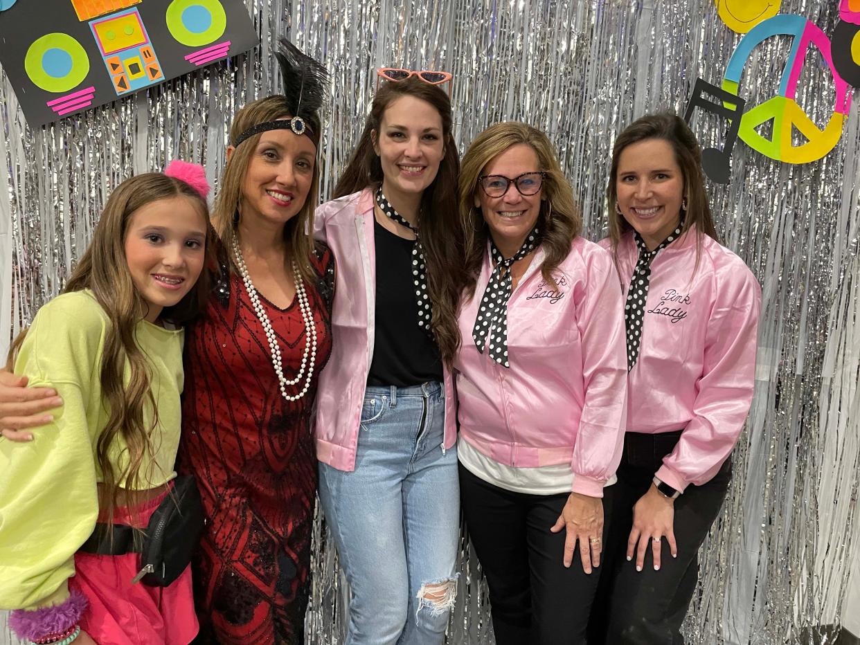 Volunteers McKenna Sparks, 12, Christine Sparks, and Joni and Friends staffers Brooke Wright, Lauren Richardson, and Channing Lewis join up at the Dancing Through the Decades event sponsored by Joni and Friends Nov. 11 at Fellowship Church on Middlebrook Pike.