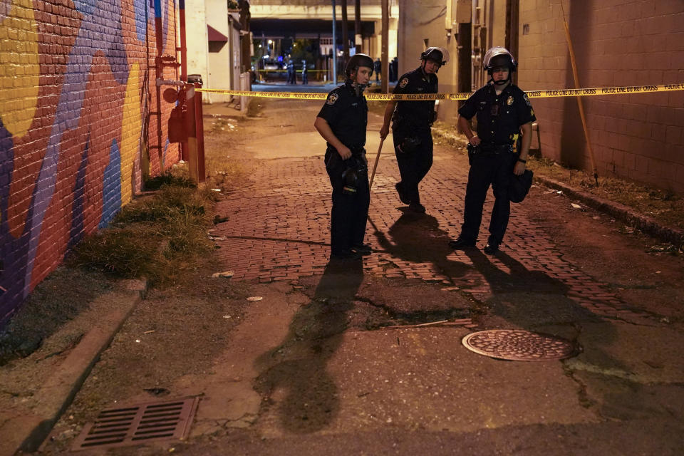 Police survey an area after a police officer was shot, Wednesday, Sept. 23, 2020, in Louisville, Ky. A grand jury has indicted one officer on criminal charges six months after Breonna Taylor was fatally shot by police in Kentucky. The jury presented its decision against fired officer Brett Hankison Wednesday to a judge in Louisville, where the shooting took place. (AP Photo/John Minchillo)