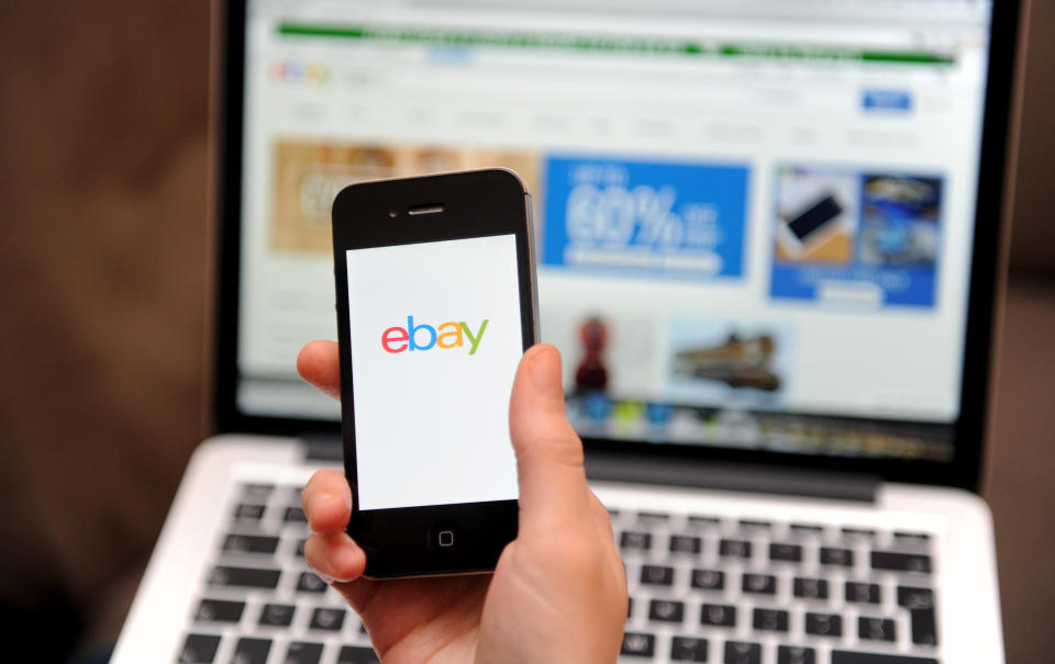 A woman uses a smartphone to browse the Ebay website