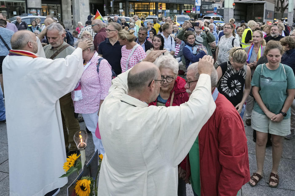FILE - Married and same-sex couples take part in a public blessing ceremony in front of the Cologne Cathedral in Cologne, Germany, on Sept. 20, 2023. Pope Francis has formally approved allowing priests to bless same-sex couples, with a new document released Monday Dec. 18, 2023 explaining a radical change in Vatican policy by insisting that people seeking God’s love and mercy shouldn’t be subject to “an exhaustive moral analysis” to receive it. (AP Photo/Martin Meissner, File)