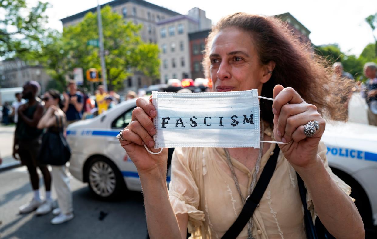 An activist holds a surgical mask during a protest of a visit by first lady Jill Biden and Dr. Anthony Fauci, director of the National Institute of Allergy and Infectious Diseases, at a vaccine clinic at the Abyssinian Baptist Church, in Harlem on June 6, 2021. 