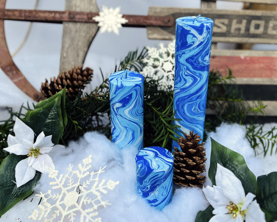 This image provided by Paula Lavender Tucker shows three blue hand-dyed marbleized candles. (Paula Lavender Tucker via AP).