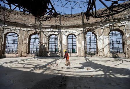 An Afghan worker sweeps inside of the ruined Darul Aman palace in Kabul, Afghanistan October 2, 2016. REUTERS/Mohammad Ismail