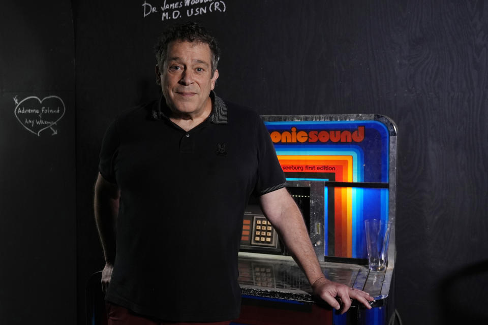 Robert Kesten, executive director of the Stonewall Museum, stands next to a juke box at the museum, Wednesday, June 26, 2024, in Fort Lauderdale, Fla. The Stonewall Museum hosts a comprehensive archive on LGBTQ+ history and the largest library collection in the world. The museum is one of hundreds of art and culture groups in the state that are left scrambling to plug a large budget gap after Gov. Ron De Santis vetoed $32 million in arts funding. (AP Photo/Marta Lavandier)