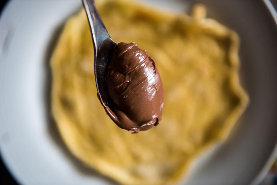 Spoonful of chocolate spread over homemade pancakes