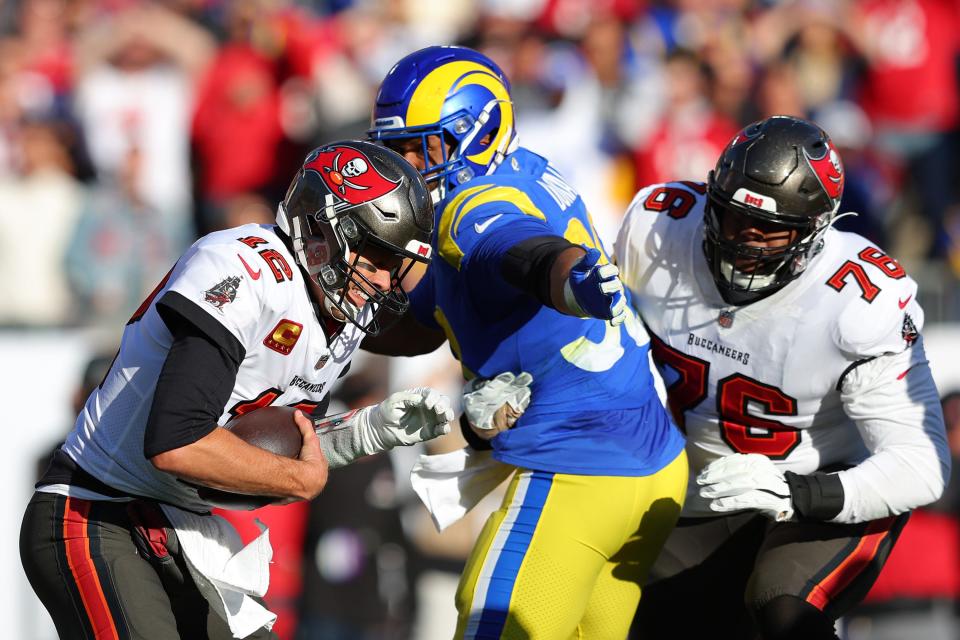 Tom Brady of the Tampa Bay Buccaneers is sacked by Aaron Donald #99 of the Los Angeles Rams in the second quarter in the NFC Divisional Playoff game at Raymond James Stadium on January 23, 2022 in Tampa, Florida.