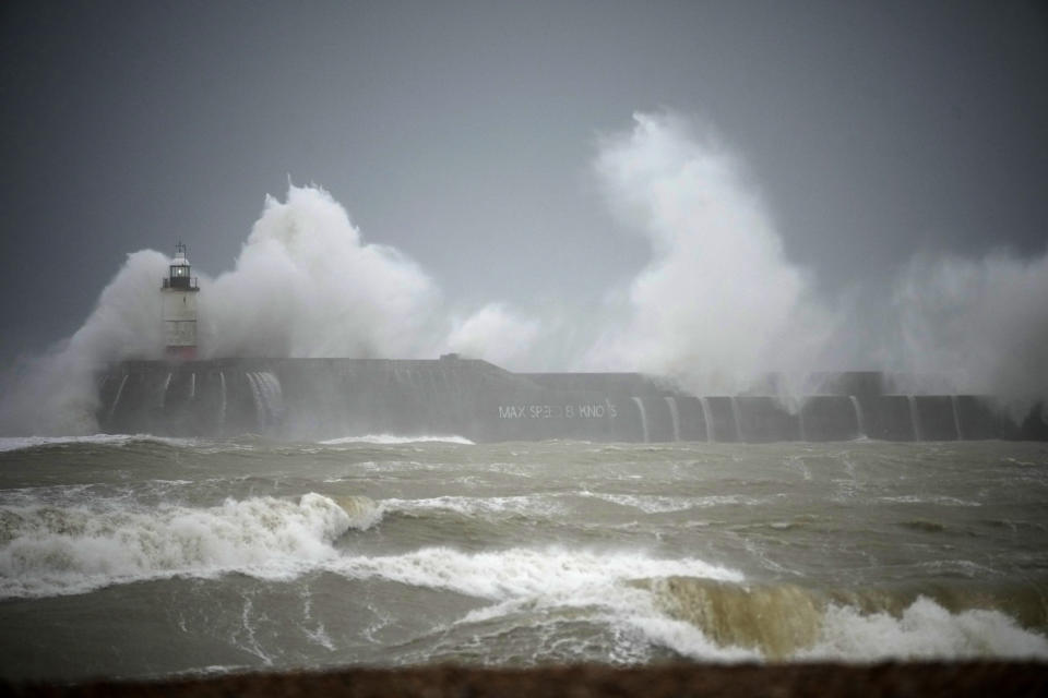 Waves crash over the Newhaven harbour breakwater and lighthouse, as Storm Eunice hits Newhaven, on the south coast of England, Friday, Feb. 18, 2022. Millions of Britons are being urged to cancel travel plans and stay indoors Friday amid fears of high winds and flying debris as the second major storm this week prompted a rare "red" weather warning, meaning there is a danger to life, across southern England. (AP Photo/Matt Dunham)