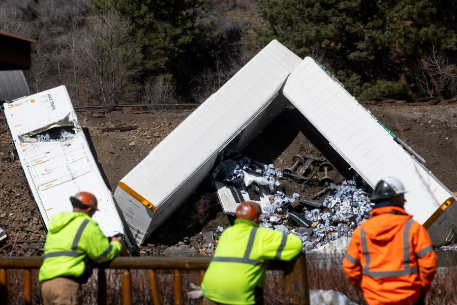 Montana Rail Link employees look across the river at rail cars which were derailed near Quinn’s Hot Springs, west St. Regis, Mont., Sunday, April 2, 2023. (Ben Allan Smith/The Missoulian via AP)