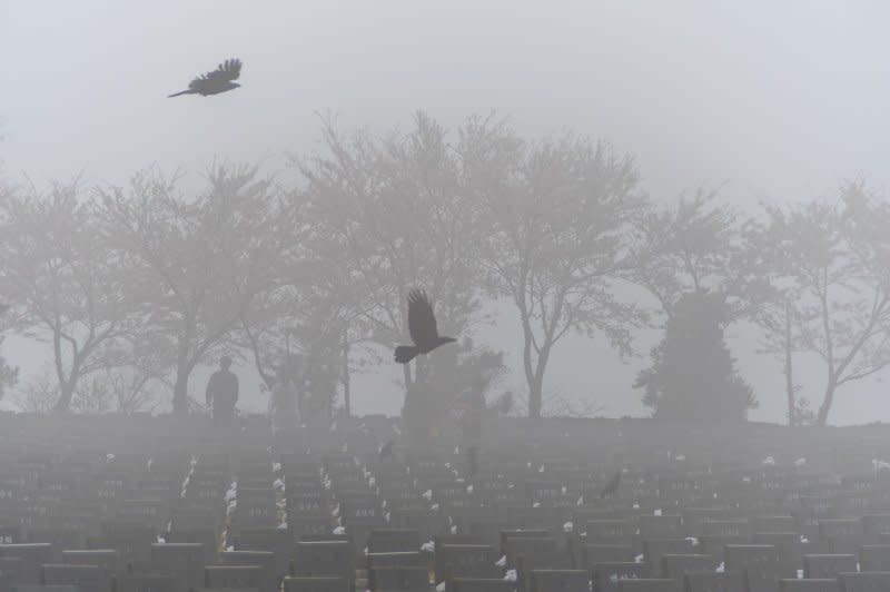 Crows fly over tombstones during a foggy 76th anniversary of the Jeju 4.3 memorial ceremony at the Jeju 4.3. Peace Park in Jeju City, South Korea, on Wednesday. Photo by Darryl Coote/UPI