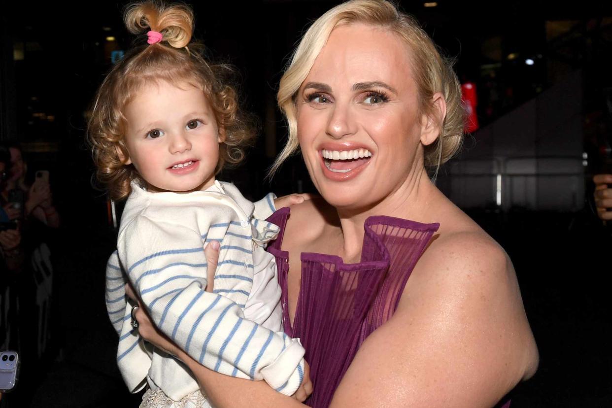 <p>Sonia Recchia/Getty </p> Rebel Wilson holds her daughter Royce at the premiere of 