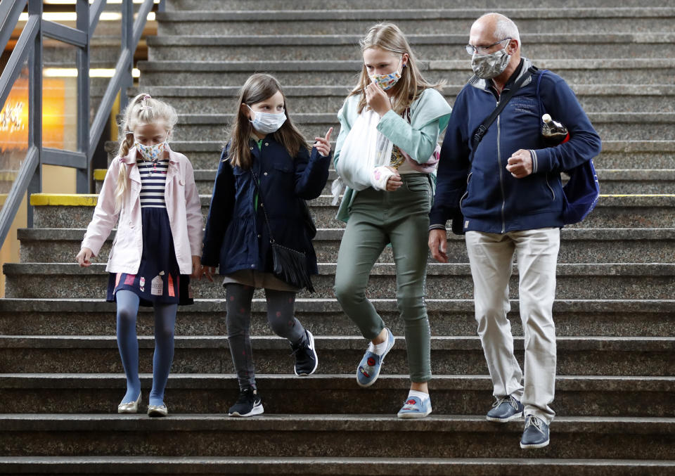 People walking into subway wear face masks on a first school day in Prague, Czech Republic, Tuesday, Sept. 1, 2020. Starting Tuesday it is mandatory that all people must cover their mouths and noses in all of public transport and some public places in affords to stem the spread of COVID-19. (AP Photo/Petr David Josek)
