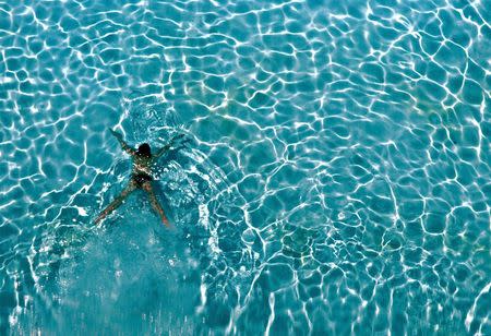 A woman swims in a hotel pool in Tampa, Florida, in this May 22, 2004 file photo. REUTERS/Shaun Best