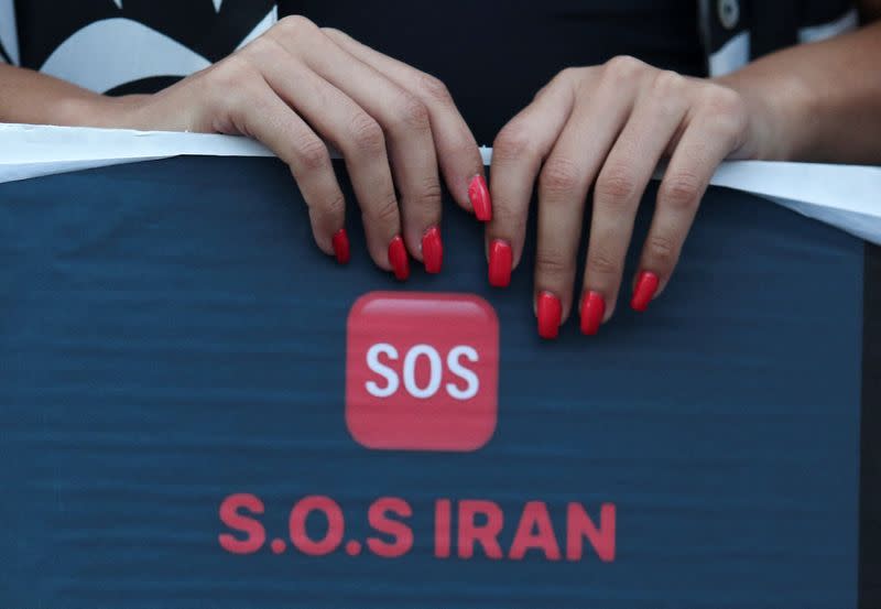 A woman holds a placard during a protest following the death of Mahsa Amini in Iran, outside the Iranian Embassy in Nicosia,