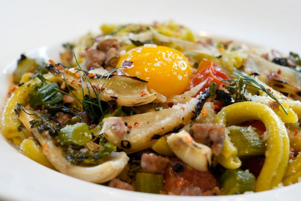 The strozzapreti verde, a pasta dish featuring Italian sausage, fennel, tomato, broccolini, basil, Parmesan cheese and an egg yolk