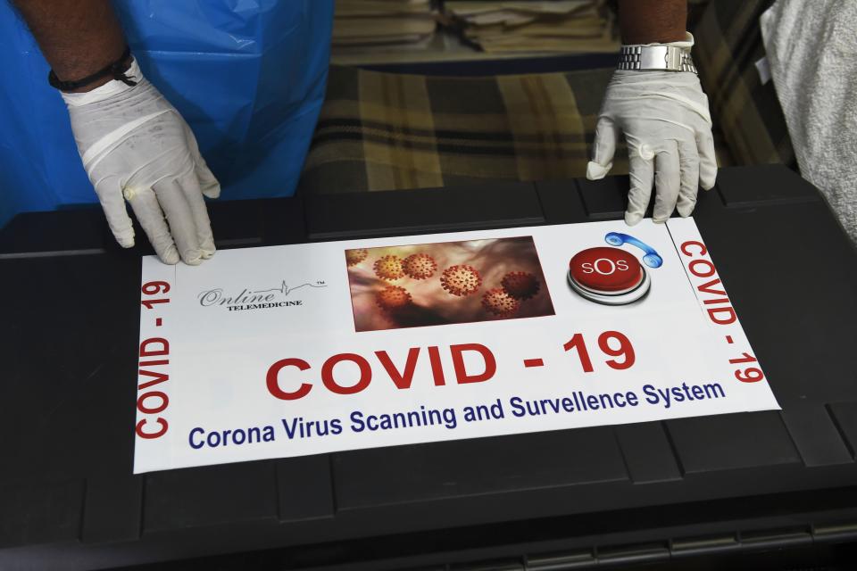 Team member of Ragesh Shah, a scientist and founder of Online Telemedicine Research Institute, puts a sticker on a kit prepared for the coronavirus scanning and surveillance system, in Ahmedabad on March 6, 2020. - India has reported 31 cases of the virus that has killed more than 3,300 people and infected nearly 100,000 worldwide after it emerged in the Chinese city of Wuhan in December. (Photo by SAM PANTHAKY / AFP) (Photo by SAM PANTHAKY/AFP via Getty Images)