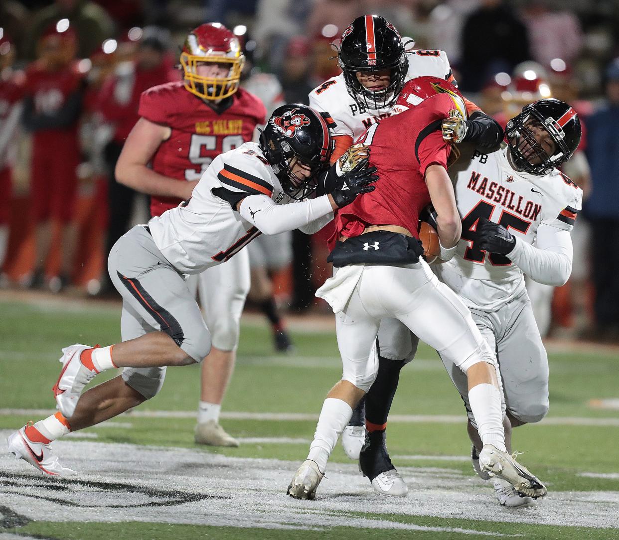 Massillon defenders, from left, Camden Beasley, Chase Bond and Michael Wright Jr. work to bring down Big Walnut QB Jake Nier in 2021 regional semifinal.