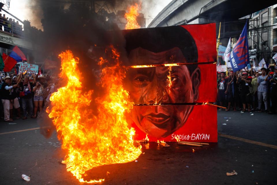 A cubic effigy painted with the face of President Rodrigo Duterte is set on fire by activists during a rally. (Photo: NurPhoto via Getty Images)