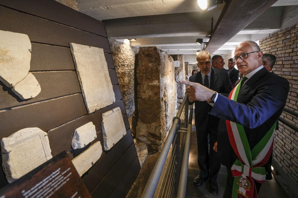 Rome's Mayor Roberto Gualtieri, right, visits the archaeological findings of the so called 'Sacred Area' where four temples, dating back as far as the 3rd century B.C., stand smack in the middle of one of modern Rome's busiest crossroads, Monday, June 19, 2023, With the help of funding from Bulgari, the luxury jeweler, the grouping of temples can now be visited by the public that for decades had to gaze down from the bustling sidewalks rimming Largo Argentina (Argentina Square) to admire the temples below where Julius Caesar masterminded his political strategies and was later fatally stabbed in 44 B.C. (AP Photo/Domenico Stinellis)