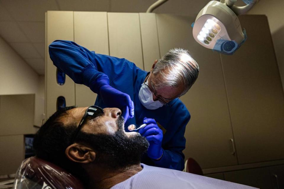 Dentist Stan Fitzer works on Mohammad Amini, an Afghan refugee who fled Afghanistan following the Taliban takeover, at Cornerstone Assistance Network in Fort Worth.