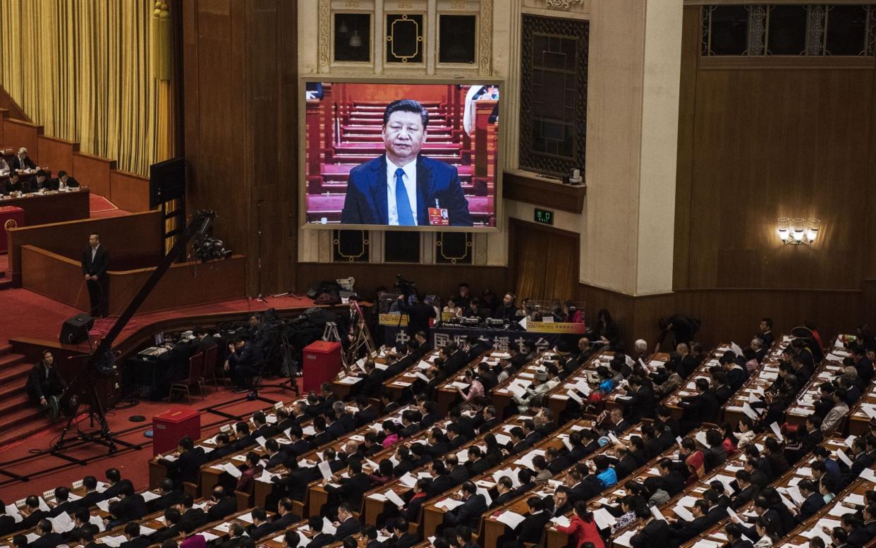  China's President Xi Jinping is seen on a large screen over delegates as he joins a session of the National People's Congress to vote on a constitutional amendment at The Great Hall Of The People on March 11, 2018 in Beijing, China - Getty Images AsiaPac